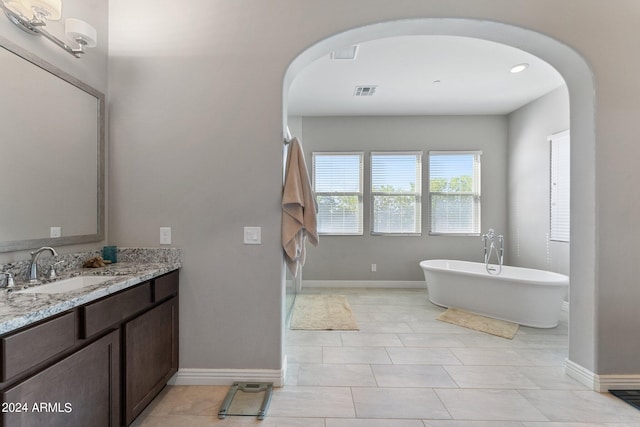 bathroom with vanity, tile patterned floors, and a bathtub