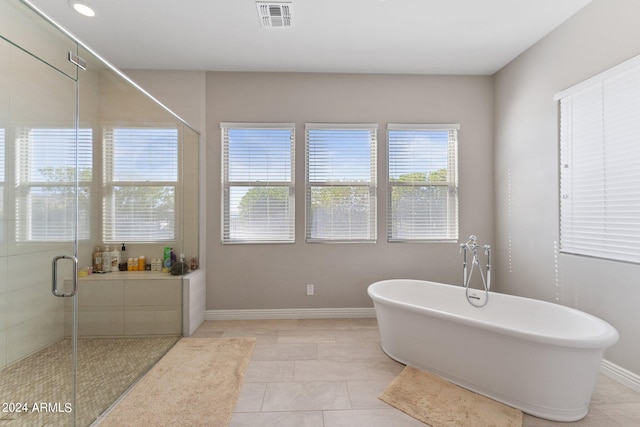 bathroom with separate shower and tub and tile patterned floors