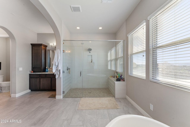 full bathroom with vanity, hardwood / wood-style floors, shower with separate bathtub, and toilet