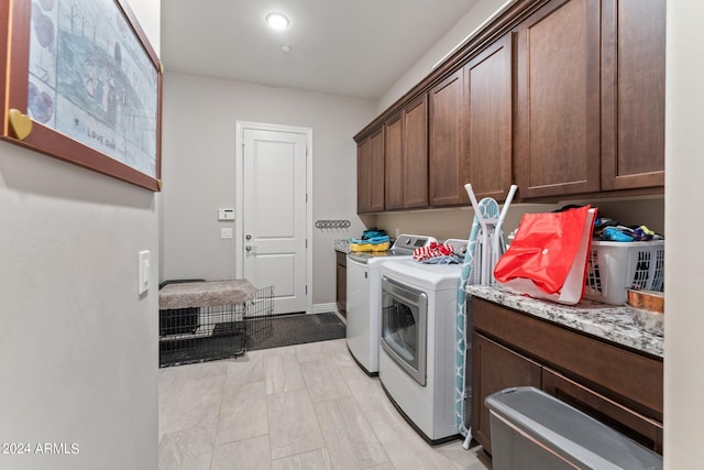 washroom featuring washing machine and dryer and cabinets