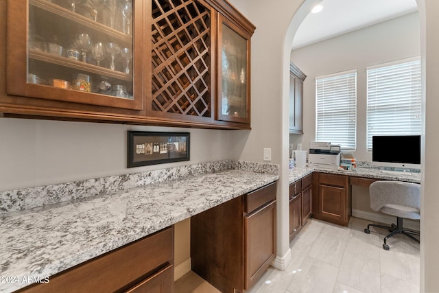 bar with built in desk and light stone counters