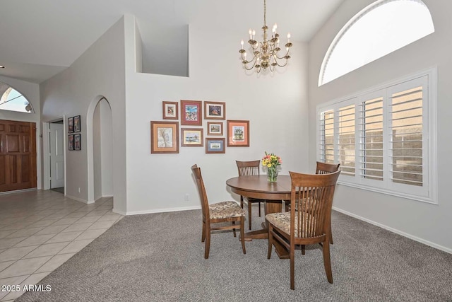 dining space featuring light carpet, a notable chandelier, and a healthy amount of sunlight