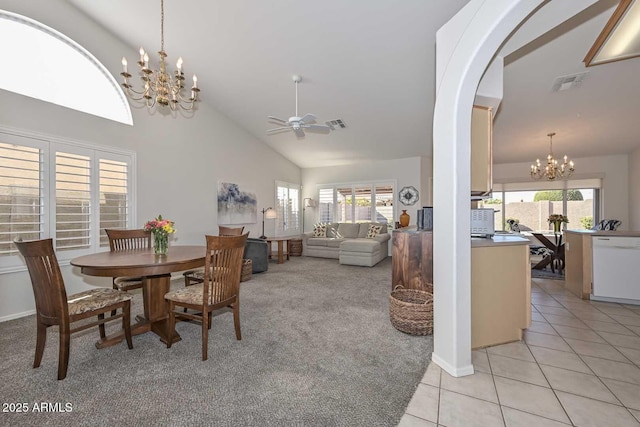 dining room featuring light tile patterned flooring, ceiling fan with notable chandelier, and high vaulted ceiling