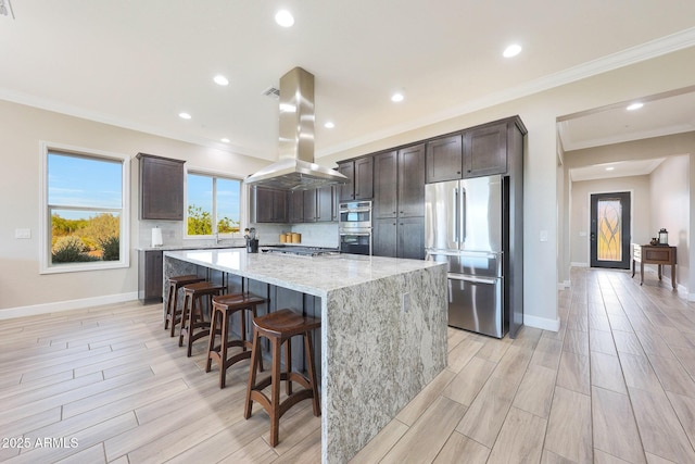 13236 W Montansoro Ln, Peoria, AZ 85383 - kitchen with stainless steel appliances, island exhaust hood, dark brown cabinets, a large island, and a breakfast bar area