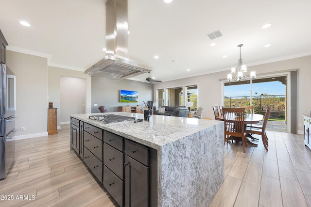 13236 W Montansoro Ln, Peoria, AZ 85383 - kitchen featuring island range hood, appliances with stainless steel finishes, light stone countertops, ornamental molding, and a kitchen island