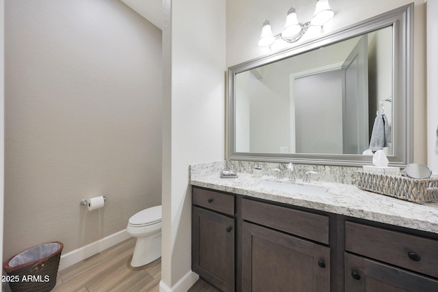 13236 W Montansoro Ln, Peoria, AZ 85383 - bathroom with wood finished floors, toilet, vanity, and baseboards