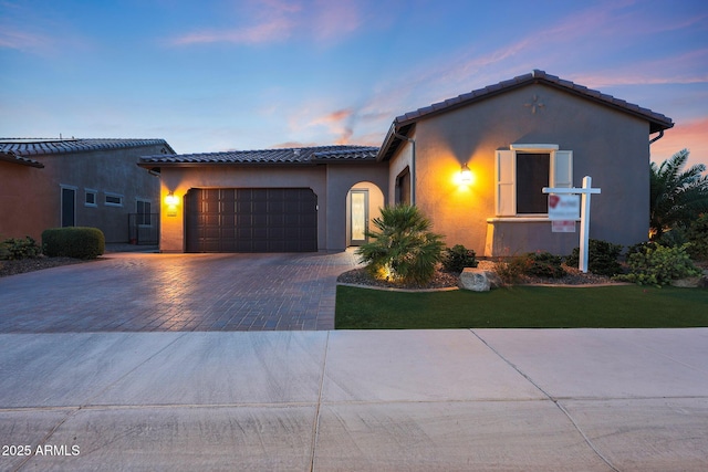 13236 W Montansoro Ln, Peoria, AZ 85383 - mediterranean / spanish-style home featuring decorative driveway, a tile roof, a garage, and stucco siding