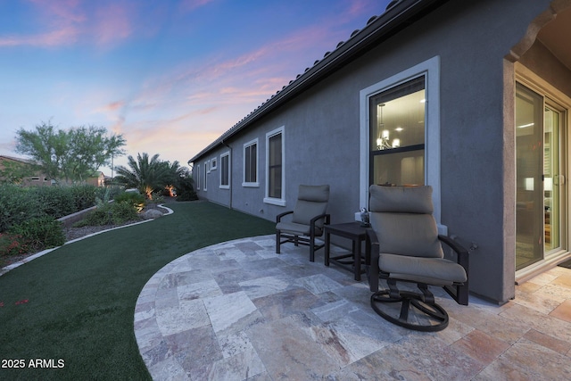 13236 W Montansoro Ln, Peoria, AZ 85383 - patio terrace at dusk featuring a patio area and a lawn