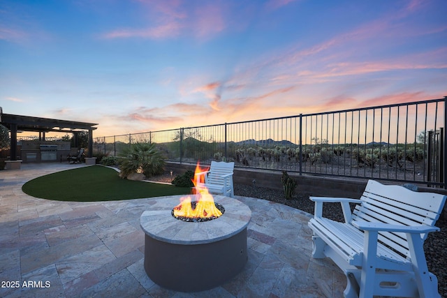 13236 W Montansoro Ln, Peoria, AZ 85383 - patio terrace at dusk featuring an outdoor fire pit, area for grilling, a patio, and a fenced backyard