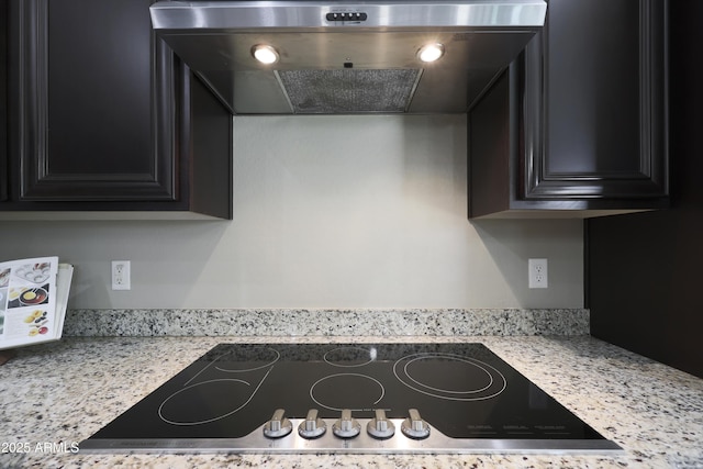 kitchen with dark cabinets, wall chimney exhaust hood, and black electric stovetop