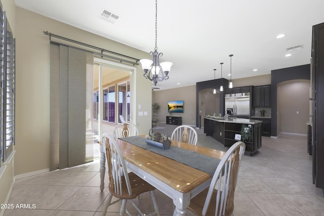 dining space with light tile patterned floors, visible vents, arched walkways, and recessed lighting