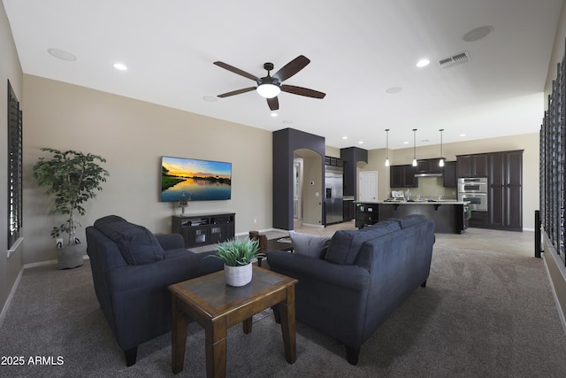 living area featuring light colored carpet, recessed lighting, a ceiling fan, baseboards, and visible vents