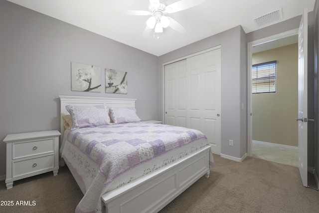 carpeted bedroom with a ceiling fan, a closet, visible vents, and baseboards