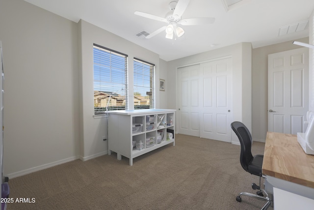 carpeted office with a ceiling fan, visible vents, and baseboards