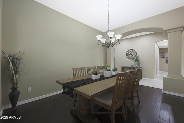 dining room with baseboards, arched walkways, and dark wood-type flooring