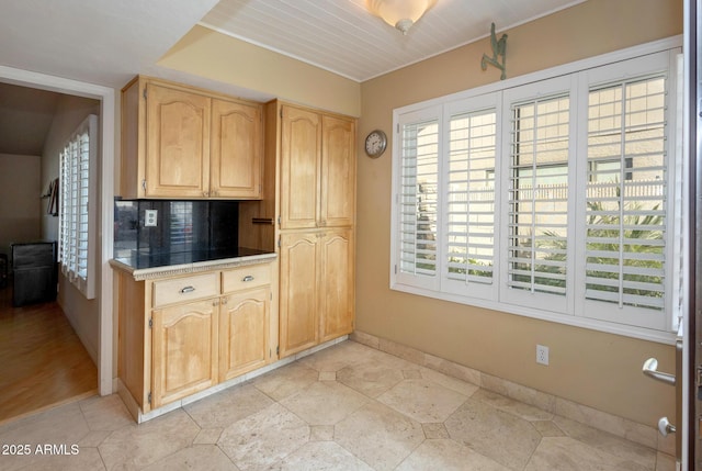 kitchen with decorative backsplash, a wealth of natural light, and light brown cabinets