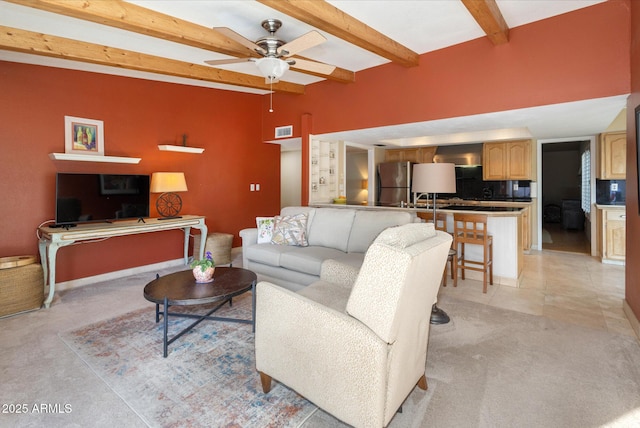 carpeted living room with ceiling fan and beam ceiling