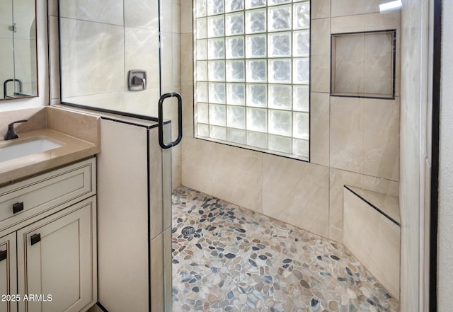 bathroom with a shower with door and vanity