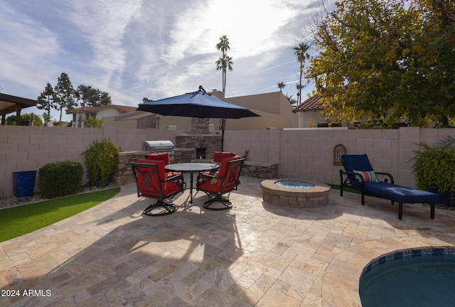 view of patio featuring a grill, an outdoor stone fireplace, and a fire pit