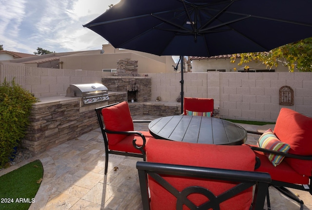 view of patio with exterior kitchen and a grill