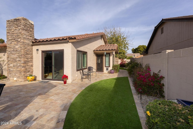 back of property featuring a patio area and a yard