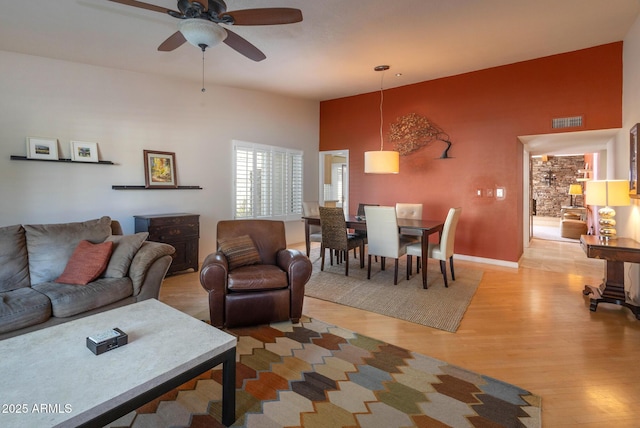 living room with light wood-type flooring and ceiling fan