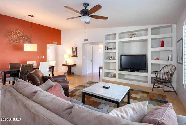 living room featuring ceiling fan, lofted ceiling, built in features, and light hardwood / wood-style flooring