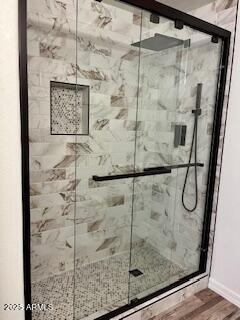 bathroom featuring a shower with shower door and wood-type flooring