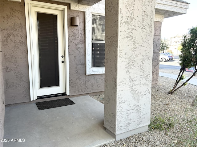 view of exterior entry with stucco siding