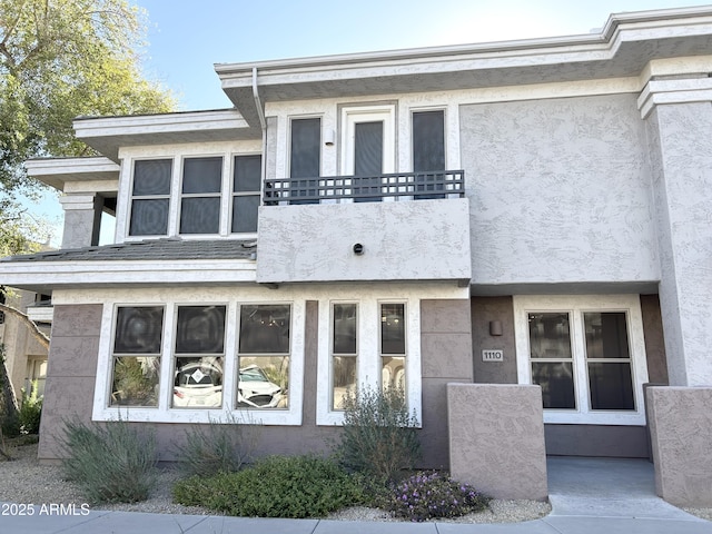 view of front of home featuring a balcony and stucco siding