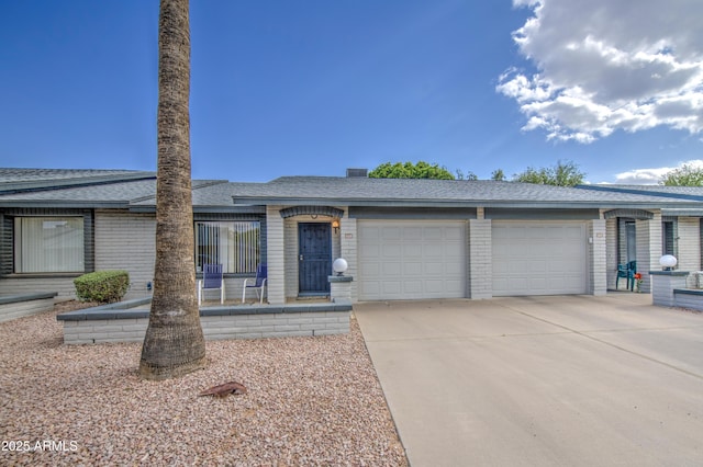 single story home featuring an attached garage, driveway, roof with shingles, and brick siding