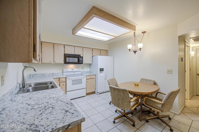 kitchen with white appliances, a sink, light countertops, light tile patterned floors, and decorative light fixtures