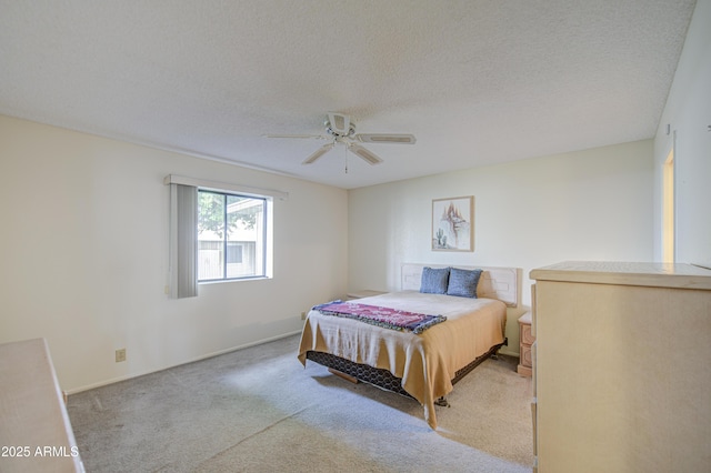 bedroom featuring carpet flooring, ceiling fan, and a textured ceiling