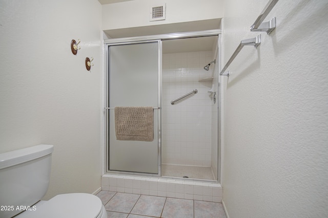 full bath with toilet, a shower stall, tile patterned floors, and baseboards
