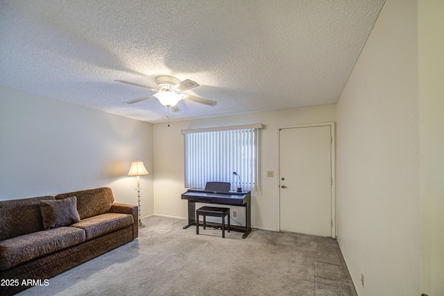 carpeted living room featuring ceiling fan, a textured ceiling, and baseboards