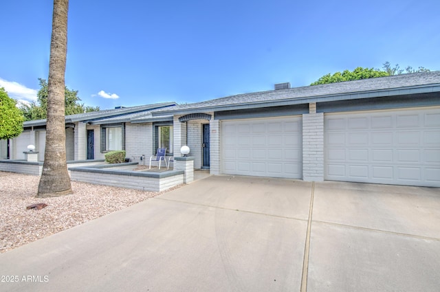 ranch-style home with driveway, a garage, and brick siding