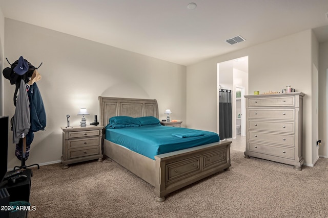 carpeted bedroom featuring ensuite bath