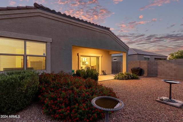 back house at dusk with a patio