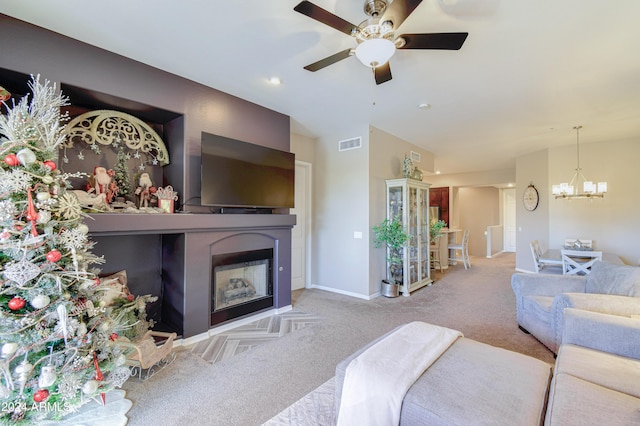 living room featuring ceiling fan with notable chandelier and light colored carpet