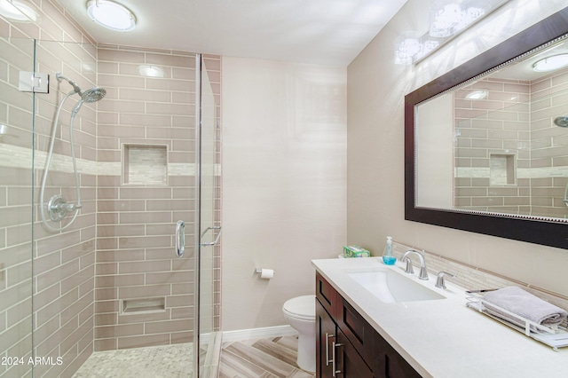 bathroom featuring vanity, toilet, and an enclosed shower