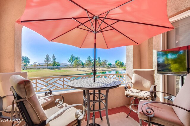 view of patio featuring a water view and a balcony