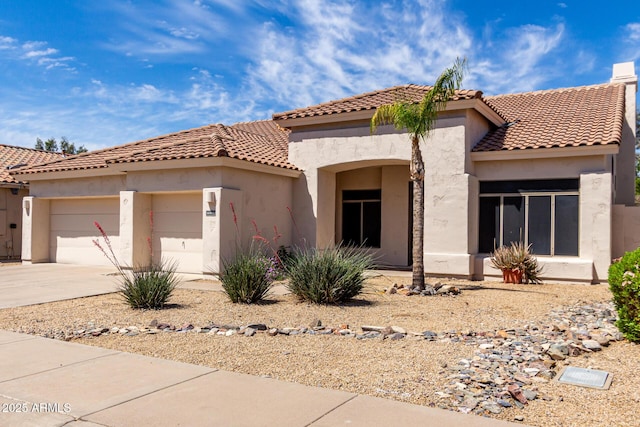 mediterranean / spanish-style house featuring an attached garage, driveway, and stucco siding