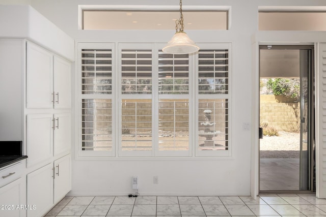 unfurnished dining area featuring marble finish floor