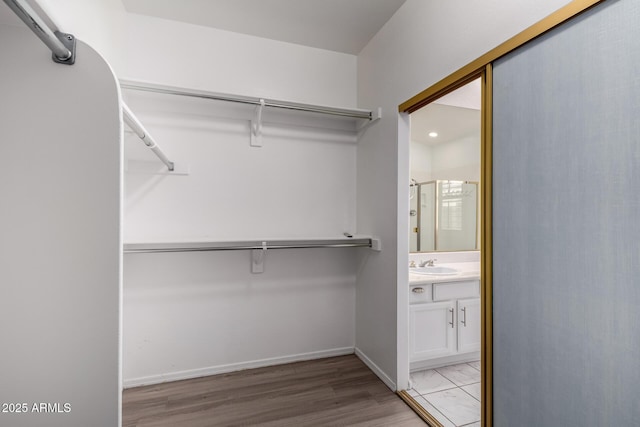 spacious closet featuring a sink and light wood-type flooring