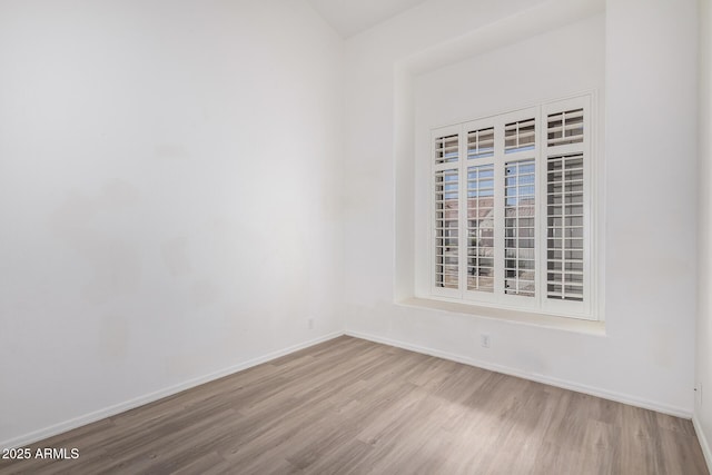 empty room with baseboards and wood finished floors