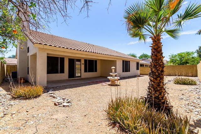 back of house with a tiled roof, a patio area, fence, cooling unit, and stucco siding