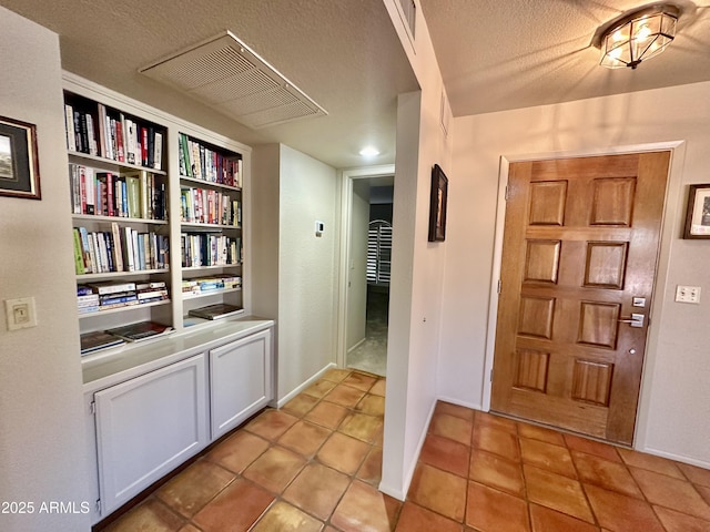 tiled foyer with a textured ceiling