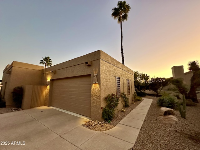 property exterior at dusk featuring a garage