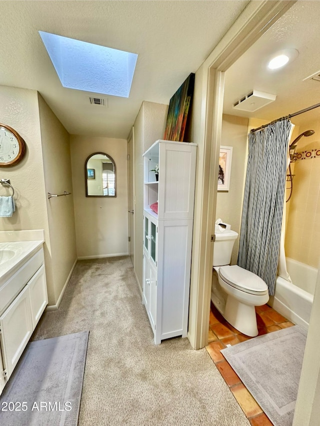 full bathroom featuring tile patterned flooring, toilet, shower / bath combo, a skylight, and vanity