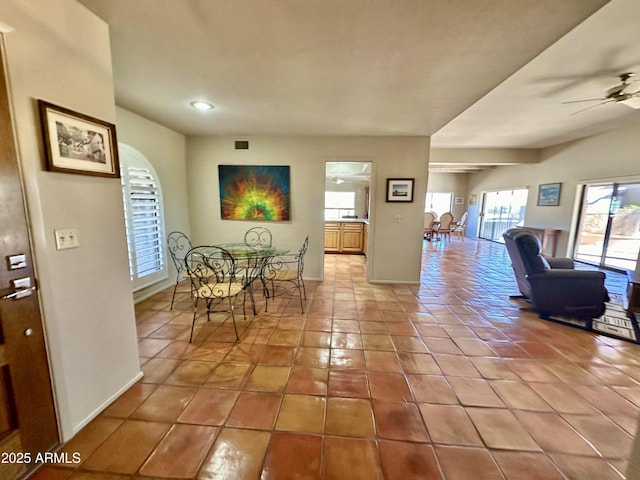 tiled dining area with ceiling fan